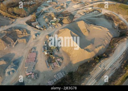 Luftaufnahme der Tagebaumine aus Sandsteinmaterialien für die Bauindustrie mit Baggern und Muldenkipper. Schwere Maschinen im Bergbau und Stockfoto