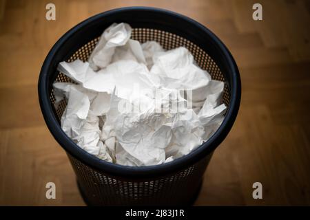 Ein Papierkorb, gefüllt mit gebrauchten Taschentüchern, nachdem er an Corona, Covid-19 oder der Grippe erkrankt war. Stockfoto