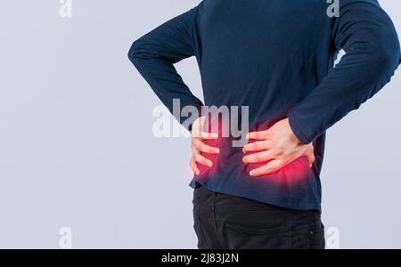 Person mit Rückenproblemen auf isoliertem Hintergrund, Konzept mit Lendenwirbelproblemen, Mann mit Wirbelsäulenproblemen, ein wund Mann mit Rückenschmerzen Stockfoto