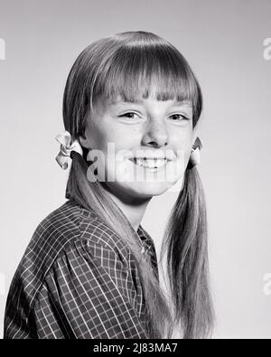 1960S PORTRAIT LÄCHELNDES MÄDCHEN, DAS MIT IHREN HAAREN IN ZÖPFEN UND KNALLEN IM KARIERTEN HEMD DIE KAMERA ANSCHAUT - J12420 HAR001 HARS SOMMERSPROSSEN VERTRAUEN S&W AUGENKONTAKT GLÜCK KOPF UND SCHULTERN FRÖHLICH UND FRISUR STOLZ SCHULE FOTO LÄCHELT AN DER KAMERA FRÖHLICHE STILVOLLE TEENAGED ZUSAMMENARBEIT WACHSTUM JUGENDLICHE MITTELSCHULE PIGTAILS PRE-TEEN PRE-TEEN MÄDCHEN KNALLT SCHWARZ UND WEISS KAUKASISCHEN ETHNIE HAR001 ALT MODISCH Stockfoto