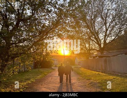 Dnipro, Dnipro, Ukraine. 12.. Mai 2022. Ein älteres ukrainisches Paar geht während des Sonnenuntergangs in einem Dorf in Dnipro, inmitten der anhaltenden russischen Invasion in der Ukraine. (Bild: © Daniel Ceng Shou-Yi/ZUMA Press Wire) Stockfoto