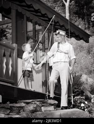 1950S KLEINER BARFUSS-JUNGE MIT ANGELSTOCK, DER HÄNDE HÄLT, UND PAPA MIT ANGELAUSRÜSTUNG, UM VOR DEM ANGELSPORT ZU GEHEN DER KABINE - J1610 HAR001 HARS ALTE ZEIT STICK NOSTALGIE GANG ALTE MODE 1 JUVENILE STIL POLE JUNGE ERWACHSENE NET TEAMWORK FLIEGEN SÖHNE ABSTRAKT ZUFRIEDEN FAMILIEN FREUDE LIFESTYLE RELIGION ARCHITEKTUR FEIER HÄUSER FISCHER LÄNDLICHES HAUS LEBEN KOPIEREN RAUM FREUNDSCHAFT IN VOLLER LÄNGE PERSONEN WOHN GEHEN FÜRSORGLICH MÄNNER GEBÄUDE HÜTTE VÄTER B & W SOMMERZEIT ZIELE GLÜCK ANGELSTOCK FRÖHLICH ABENTEUER EIGENSCHAFT VÄTER AUFREGUNG AUSSEN VATER UND SOHN SIND STOLZ DARAUF, IHRE HÄNDE BARFUSS ZU HAUSE ZU HALTEN Stockfoto