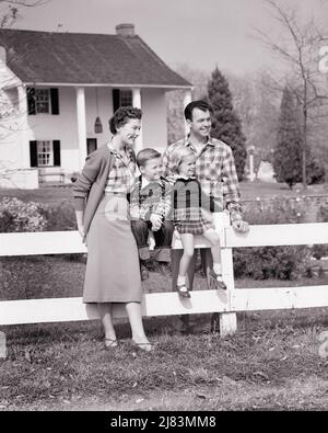 1950S FAMILIE VON 4 DURCH WEISSEN ZAUN VOR DEM ZWEISTÖCKIGEN HAUS MIT SÄULEN JUNGE UND MÄDCHEN SITZEN AUF ZAUN ELTERN STEHEN - J3184 HAR001 HARS GESCHICHTE NOSTALGISCHES PAAR 4 VORSTADTFRÜHLINGSMÜTTER ALTE ZEIT NOSTALGIE BRUDER ALTE MODE SCHWESTER JUGENDSTIL WILLKOMMEN JUNGE ERWACHSENE ABSTRAKT ZUFRIEDEN FAMILIEN FREUDE LIFESTYLE FRAUEN HÄUSER VERHEIRATET BRÜDER EHEGATTEN EHEMÄNNER GESUNDHEIT ZU HAUSE LEBEN RAUM KOPIEREN FREUNDSCHAFT GANZKÖRPERFRAUEN PERSONEN WOHNEN PFLEGE MÄNNER GEBÄUDE GESCHWISTER SCHWESTERN VÄTER B&W PARTNER TRÄUMT GLÜCK FRÖHLICH UND VÄTER ÄUSSERE STOLZ SPALTEN HÄUSER GESCHWISTER LÄCHELT VERBINDUNG FRÖHLICH Stockfoto