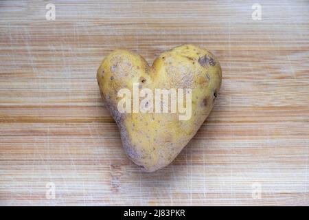 Kartoffel in Herzform auf einem Holzhackbrett, Baden-Württemberg Stockfoto