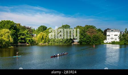 Ruderer und Stehpaddler auf der Alster bei Winterhude, Hamburg, Deutschland Stockfoto