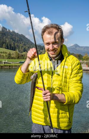 Mann hält Forellen gefangen, Angeln Stockfoto