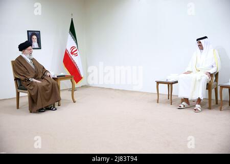 Teheran, Teheran, Iran. 12.. Mai 2022. Ein Handout-Foto, das vom Büro des iranischen Obersten Führers zur Verfügung gestellt wurde, zeigt, dass der iranische Oberste Führer Ayatollah ALI KHAMENEI (L) während eines Treffens in Teheran, Iran, am 12. Mai 2022 mit dem Emir von Katar, Scheich TAMIM bin HAMAD AL THANI (R), sprach. Al Thani ist in Teheran, um sich mit iranischen Beamten zu treffen. Der Emir von Katar und die Europäische Union haben heute erklärt, dass sie daran arbeiten, die festgefahrenen Verhandlungen zur Wiederbelebung eines Atomabkommen zwischen dem Iran und den großen Weltmächten aus dem Jahr 2015 voranzutreiben. (Bild: © Büro des Obersten iranischen Führers über ZUMA Press Wire) Stockfoto