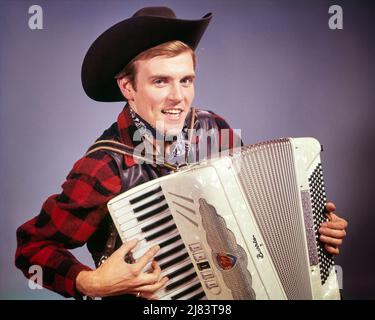 1960S LÄCHELNDER MANN MIT COWBOY-HUT, DER AUF EINEM AKKORDEON COUNTRY-WESTERN-MUSIK SPIELT UND DIE KAMERA ANSCHAUT - KM1279 HAR001 HARS SÄNGER JUNGE ERWACHSENE SÄNGER ERFREUT FREUDE LIFESTYLE SOUND ZUFRIEDENHEIT SCHAUSPIELER MUSIKER STUDIO SCHOSS LÄNDLICHE GESUNDHEIT WOLLE KOPIEREN RAUM FREUNDSCHAFT HALBE LÄNGE PERSONEN CHARAKTER MÄNNER WESTERN PLAID BERUF UNTERHALTUNG VERTRAUEN AMERICANA AUSDRÜCKE BLICKKONTAKT COWBOYS PERFORMING ARTS BERUF GLÜCK AKKORDEON KOPF UND SCHULTERN FRÖHLICHER DARSTELLER UND KARRIERE SPANNENDES LIED VOCAL PRIDE ENTERTAINER BERUFE LÄCHELT MUSIKINSTRUMENT VOKALISIEREN KONZEPTUELLE VOCALS SCHAUSPIELER Stockfoto