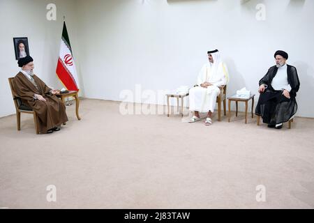 12. Mai 2022, Teheran, Teheran, Iran: Ein Handout-Foto, das vom Büro des iranischen Obersten Führers zur Verfügung gestellt wurde, zeigt, dass der iranische Oberste Führer Ayatollah ALI KHAMENEI (L) während eines Treffens in Teheran, Iran, am 12. Mai 2022, mit dem Emir von Katar, Scheich TAMIM bin HAMAD AL THANI (C), spricht, wie der iranische Präsident EBRAHIM RAISI (R) anschaut. Al Thani ist in Teheran, um sich mit iranischen Beamten zu treffen. Der Emir von Katar und die Europäische Union haben heute erklärt, dass sie daran arbeiten, die festgefahrenen Verhandlungen zur Wiederbelebung eines Atomabkommen zwischen dem Iran und den großen Weltmächten aus dem Jahr 2015 voranzutreiben. (Bild: © Büro des Obersten iranischen Führers Stockfoto