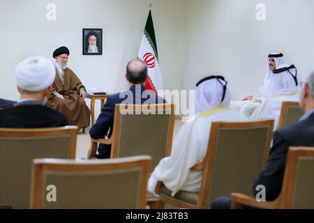 Teheran, Teheran, Iran. 12.. Mai 2022. Ein Handout-Foto, das vom Büro des iranischen Obersten Führers zur Verfügung gestellt wurde, zeigt, dass der iranische Oberste Führer Ayatollah ALI KHAMENEI (L) während eines Treffens in Teheran, Iran, am 12. Mai 2022 mit dem Emir von Katar, Scheich TAMIM bin HAMAD AL THANI (R), sprach. Al Thani ist in Teheran, um sich mit iranischen Beamten zu treffen. Der Emir von Katar und die Europäische Union haben heute erklärt, dass sie daran arbeiten, die festgefahrenen Verhandlungen zur Wiederbelebung eines Atomabkommen zwischen dem Iran und den großen Weltmächten aus dem Jahr 2015 voranzutreiben. (Bild: © Büro des Obersten iranischen Führers über ZUMA Press Wire) Stockfoto