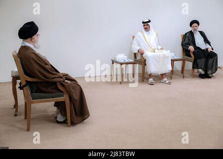 12. Mai 2022, Teheran, Teheran, Iran: Ein Handout-Foto, das vom Büro des iranischen Obersten Führers zur Verfügung gestellt wurde, zeigt, dass der iranische Oberste Führer Ayatollah ALI KHAMENEI (L) während eines Treffens in Teheran, Iran, am 12. Mai 2022, mit dem Emir von Katar, Scheich TAMIM bin HAMAD AL THANI (C), spricht, wie der iranische Präsident EBRAHIM RAISI (R) anschaut. Al Thani ist in Teheran, um sich mit iranischen Beamten zu treffen. Der Emir von Katar und die Europäische Union haben heute erklärt, dass sie daran arbeiten, die festgefahrenen Verhandlungen zur Wiederbelebung eines Atomabkommen zwischen dem Iran und den großen Weltmächten aus dem Jahr 2015 voranzutreiben. (Bild: © Büro des Obersten iranischen Führers Stockfoto