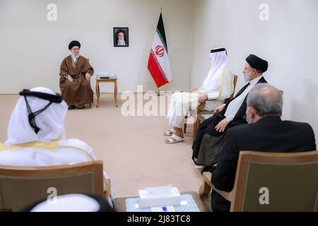 12. Mai 2022, Teheran, Teheran, Iran: Ein Handout-Foto, das vom Büro des iranischen Obersten Führers zur Verfügung gestellt wurde, zeigt, dass der iranische Oberste Führer Ayatollah ALI KHAMENEI (L) während eines Treffens in Teheran, Iran, am 12. Mai 2022, mit dem Emir von Katar, Scheich TAMIM bin HAMAD AL THANI (C), spricht, wie der iranische Präsident EBRAHIM RAISI (R) anschaut. Al Thani ist in Teheran, um sich mit iranischen Beamten zu treffen. Der Emir von Katar und die Europäische Union haben heute erklärt, dass sie daran arbeiten, die festgefahrenen Verhandlungen zur Wiederbelebung eines Atomabkommen zwischen dem Iran und den großen Weltmächten aus dem Jahr 2015 voranzutreiben. (Bild: © Büro des Obersten iranischen Führers Stockfoto