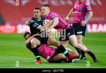 Huddersfield Giants' Tuimoala Lolohea wurde von Iain Thornley (links) und Sam Halsall von Wigan Warriors während des Betfred Super League-Spiels im John Smith's Stadium, Huddersfield, angegangen. Bilddatum: Donnerstag, 1212. Mai 2022. Stockfoto