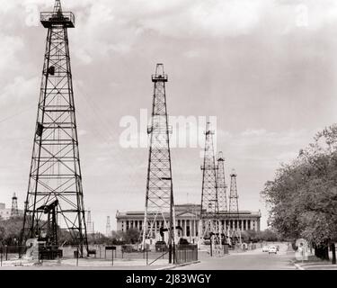 1940S 1950S STATE CAPITOL GEBÄUDE UMGEBEN VON ÖLDERRICKS EINE KUPPEL WURDE 2002 FERTIGGESTELLT OKLAHOMA CITY OKLAHOMA USA - R10385 HAR001 HARS STRUKTUREN STÄDTE FERTIGGESTELLTE GEBÄUDE 2002 OKLAHOMA CITY PETROLEUM SCHWARZ-WEISS-DERRICKS FOSSILE BRENNSTOFFE HAR001 ALTMODISCH Stockfoto