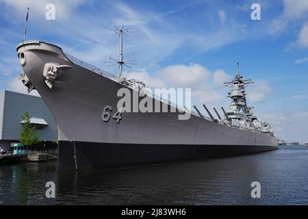 Seitenansicht der USS Wisconsin (BB-64) an ihrem Liegeplatz in Norfolk, VA. Die USS Wisconsin liegt neben Nauticus, dem National Maritime Center. Stockfoto