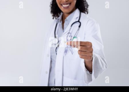 Mittelteil einer glücklichen afroamerikanischen Ärztin mit mittlerem Erwachsenen und weißem Lungenkrebsband Stockfoto