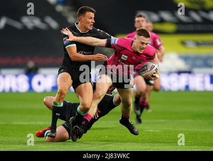 Sam Halsall von Wigan Warriors wurde von Louis Senior von Huddersfield Giants (links) und Tuimoala Lolohea während des Betfred Super League-Spiels im John Smith's Stadium, Huddersfield, angegangen. Bilddatum: Donnerstag, 1212. Mai 2022. Stockfoto