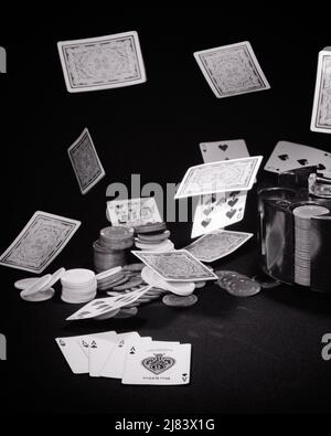 1970S SYMBOLISCHES GLÜCKSSPIEL FALLENDE SPIELKARTEN STAPEL VON POKERCHIPS UND FÜNF ASSEN, DIE IM VORDERGRUND ANGEZEIGT WERDEN BETRUG - S20922 HAR001 HARS WETTE SPADES ASSE ANTE SYMBOLISCHE KARTENSPIELE BETRUGSKONZEPTE ACE-WETTE SCHWARZ-WEISS-CHANCE VORDERGRUND HAR001 ALTMODISCHE DARSTELLUNG Stockfoto