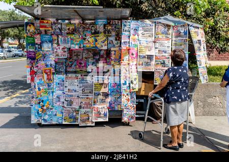 Eine Einheimische, die sich die Schlagzeilen der Zeitung an Einem Zeitungskioster in Trujillo, Provinz La Libertad, Peru, ansieht. Stockfoto