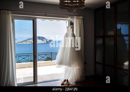 Hochzeit Kleid hängen an der Fenster im Zimmer. Stockfoto