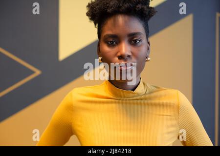 Porträt einer jungen afroamerikanischen Beiberaterin, die am Arbeitsplatz steht Stockfoto