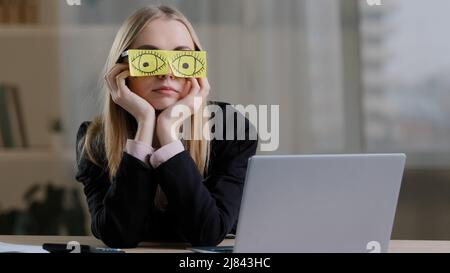 Müde, müde, lustig, faul, kaukasische Geschäftsfrau mit klebrigen Notizen auf einer Augenbrille mit Aufklebern. Ermüdete Arbeitnehmerin, die am Arbeitsplatz beim Nickerchen ansitzt Stockfoto