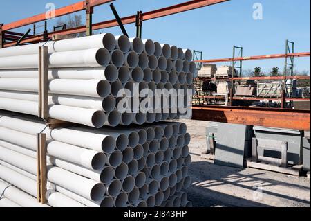 Verpackte Wasserrohre aus Kunststoff, die in Reihen im Lager gestapelt sind. Platz zum Hinzufügen von Text kopieren. Stockfoto