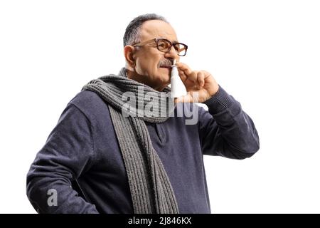 Reifer Mann sprüht ein Medikament in seine Nase isoliert auf weißem Hintergrund Stockfoto