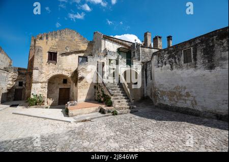 Mdera, Basilikata, Italien. August 2021. Toller Blick auf einen Innenhof mit Häusern im historischen Zentrum, der aus Tuffsteinblöcken erbaut wurde. Stadtlandschaft Stockfoto