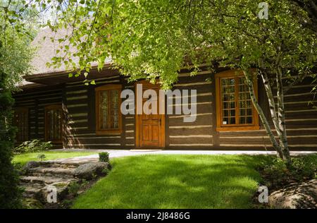 Alte rekonstruierte Blockhaus-Fassade aus dem Jahr 1800s im kanadischen Cottage-Stil im Sommer. Stockfoto