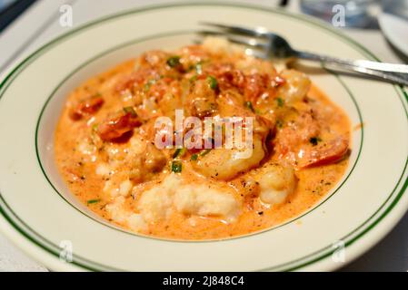 Gulf Shrimps und Cheddar Grits mit Knoblauch, chardonnay Wein-Sahnesauce, in Ginny Lane Bar & Grill at the Wharf, Gulf Shores, Alabama, USA Stockfoto