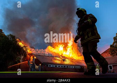 Hannover, Deutschland. 12.. Mai 2022. Eine Turnhalle der Schillerschule im Stadtteil Kleefeld ist in Flammen. Großalarm für die Feuerwehr Hannover: Aus noch ungeklärter Ursache ist in zwei Turnhallen einer Schule im Landkreis Kleefeld ein Brand ausgebrochen. Es gab zunächst keine Hinweise auf Verletzte. Quelle: Moritz Frankenberg/dpa/Alamy Live News Stockfoto