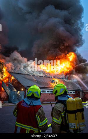 Hannover, Deutschland. 12.. Mai 2022. Eine Turnhalle der Schillerschule im Stadtteil Kleefeld ist in Flammen. Großalarm für die Feuerwehr Hannover: Aus noch ungeklärter Ursache ist in zwei Turnhallen einer Schule im Landkreis Kleefeld ein Brand ausgebrochen. Quelle: Moritz Frankenberg/dpa/Alamy Live News Stockfoto