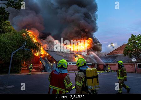 Hannover, Deutschland. 12.. Mai 2022. Eine Turnhalle der Schillerschule im Stadtteil Kleefeld ist in Flammen. Großalarm für die Feuerwehr Hannover: Aus noch ungeklärter Ursache ist in zwei Turnhallen einer Schule im Landkreis Kleefeld ein Brand ausgebrochen. Es gab zunächst keine Hinweise auf Verletzte. Quelle: Moritz Frankenberg/dpa/Alamy Live News Stockfoto