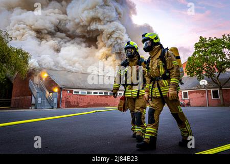 Hannover, Deutschland. 12.. Mai 2022. Eine Turnhalle der Schillerschule im Stadtteil Kleefeld ist in Flammen. Großalarm für die Feuerwehr Hannover: Aus noch ungeklärter Ursache ist in zwei Turnhallen einer Schule im Landkreis Kleefeld ein Brand ausgebrochen. Es gab zunächst keine Hinweise auf Verletzte. Quelle: Moritz Frankenberg/dpa/Alamy Live News Stockfoto