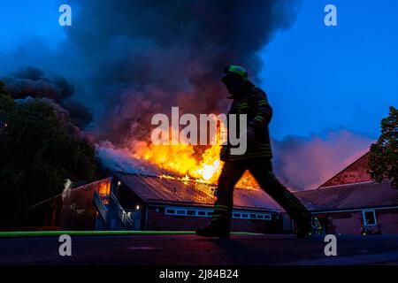 Hannover, Deutschland. 12.. Mai 2022. Eine Turnhalle der Schillerschule im Stadtteil Kleefeld ist in Flammen. Großalarm für die Feuerwehr Hannover: Aus noch ungeklärter Ursache ist in zwei Turnhallen einer Schule im Landkreis Kleefeld ein Brand ausgebrochen. Es gab zunächst keine Hinweise auf Verletzte. Quelle: Moritz Frankenberg/dpa/Alamy Live News Stockfoto