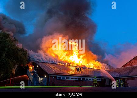 Hannover, Deutschland. 12.. Mai 2022. Eine Turnhalle der Schillerschule im Stadtteil Kleefeld ist in Flammen. Großalarm für die Feuerwehr Hannover: Aus noch ungeklärter Ursache ist in zwei Turnhallen einer Schule im Landkreis Kleefeld ein Brand ausgebrochen. Es gab zunächst keine Hinweise auf Verletzte. Quelle: Moritz Frankenberg/dpa/Alamy Live News Stockfoto