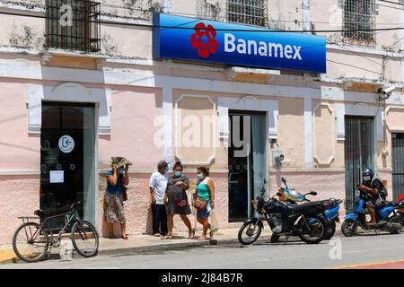 Menschen, die unter der Hitze vor der mexikanischen Banamex-Bank in der Stadt Ticul, Yucatan, Mexiko, warten Stockfoto