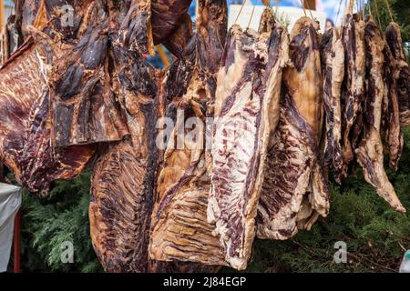 Bild eines serbischen geräucherten und getrockneten Fleisches, Schweinefleisch, Schinken, auf einer Rute auf dem Land von Serbien. Stockfoto