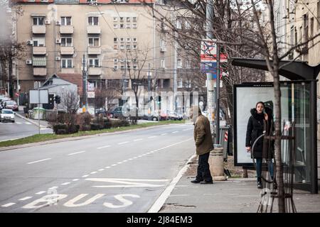 Bild eines Schildes einer Bushaltestelle des Belgrader öffentlichen Nahverkehrs auf der Trg Republike mit einem alten Mann, der auf einen Bus wartet. GSP Belgrad ist ein Pub Stockfoto