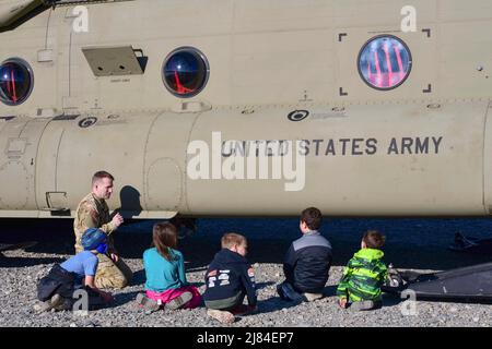 Talkeetna, Alaska, USA. 27. April 2022. Chief Warrant Officer 4 Francois Collard spricht mit einer Gruppe von Talkeetna, Alaska, Grundschulkindern über den CH-47F Chinook Hubschrauber der Armee vom 27. April 2022. Die Sugar Bears of B Company, 1. Bataillon und 52. Aviation Regiment fliegen jedes Frühjahr von Talkeetna aus, um den National Park Service zu unterstützen und Erfahrungen im Hochland-Betrieb zu sammeln. Kredit: U.S. Army/ZUMA Press Wire Service/ZUMAPRESS.com/Alamy Live Nachrichten Stockfoto