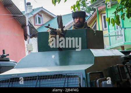 Srinagar, Indien, 11. Mai 2022, Srinagar, Jammu und Kaschmir, Indien: Der indische paramilitärische Trooper steht auf der Oberseite eines gepanzerten Fahrzeugs vor einem Regierungsbüro im Gebiet Chadoora im zentralen Budgam-Distrikt von Kaschmir, wo ein Mitarbeiter der Kashmiri Pandit-Gemeinde von Militanten getötet wurde. Dieser Angriff kommt einen Tag nach zwei getrennten Begegnungen in den Bezirken Bandipora und Anantnag in der umstrittenen Region. (Bild: © Faisal Bashir/SOPA Images via ZUMA Press Wire) Stockfoto