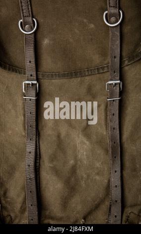 Nahaufnahme Textur eines Rucksack aus Canvas-Stoff. Lederriemen und Metallschnallen. Vintage Khaki Hintergrund. Stockfoto