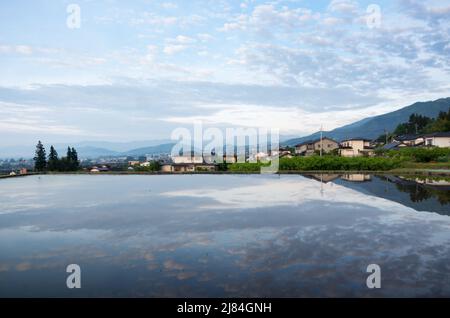 iida, nagano, japan, 2022/12/05 , Reisfelder in iida Nagano, im Frühling, während der Überflutung der Felder, so dass sie wie ein Spiegel aussehen. Stockfoto