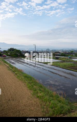 iida, nagano, japan, 2022/12/05 , Reisfelder in iida Nagano, im Frühling, während der Überflutung der Felder, so dass sie wie ein Spiegel aussehen. Stockfoto