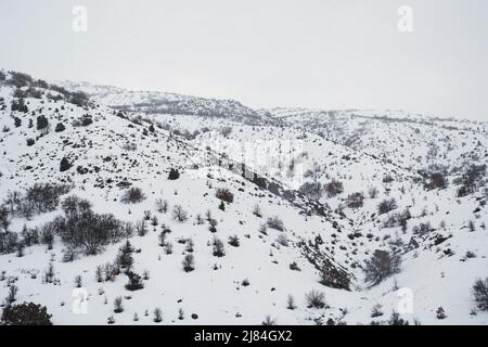 Landschaft Blick auf verschneite Berge und Hügel von der Zugfahrt und im Winter in zentralanatolien. Stockfoto