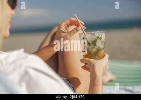 Mojito Cocktail mit Limette und Minze in Highballglas in weiblichen Händen Stockfoto