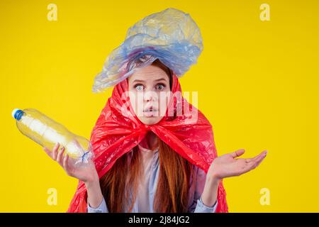 Rotschopf Ingwer Mädchen mit Bestürzung auf ihrem Gesicht zeigt Finger Copyspase mit schlecht voll von nicht-Öko-Kunststoff-Müll in Studio gelben Hintergrund Stockfoto