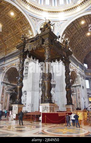 Touristen bewundern Berninis Baldacchino in der Petersbasilika, Vatikanstadt, Vatikan. Stockfoto