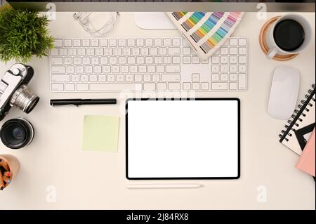 Grafik-Designer-Arbeitsbereich, Draufsicht mit weißem Tablet-Bildschirm, Farbpalette, Kamera, Computer und Zubehör. Stockfoto